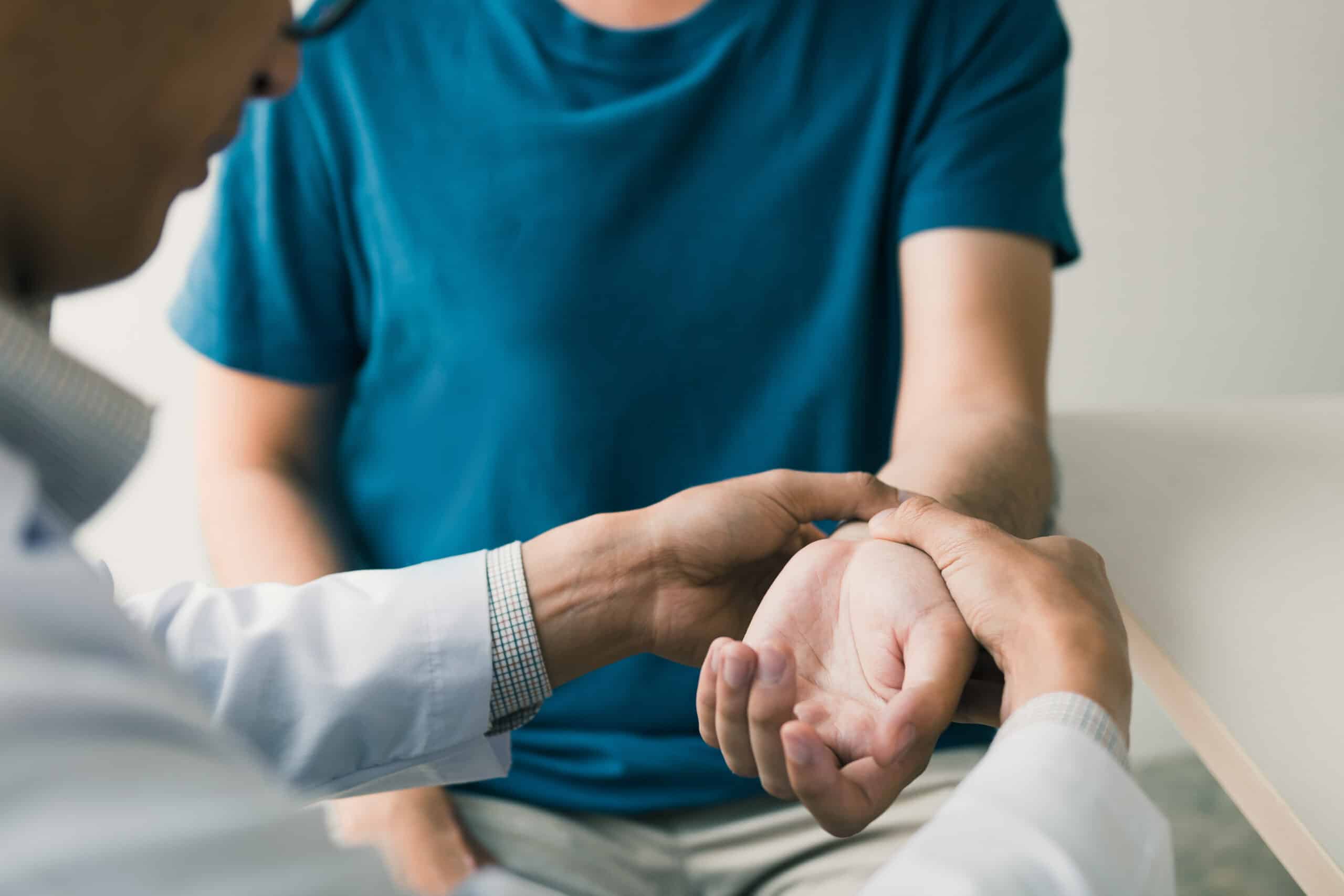 Physical Therapist Checks The Patient Wrist By Pressing The Wrist