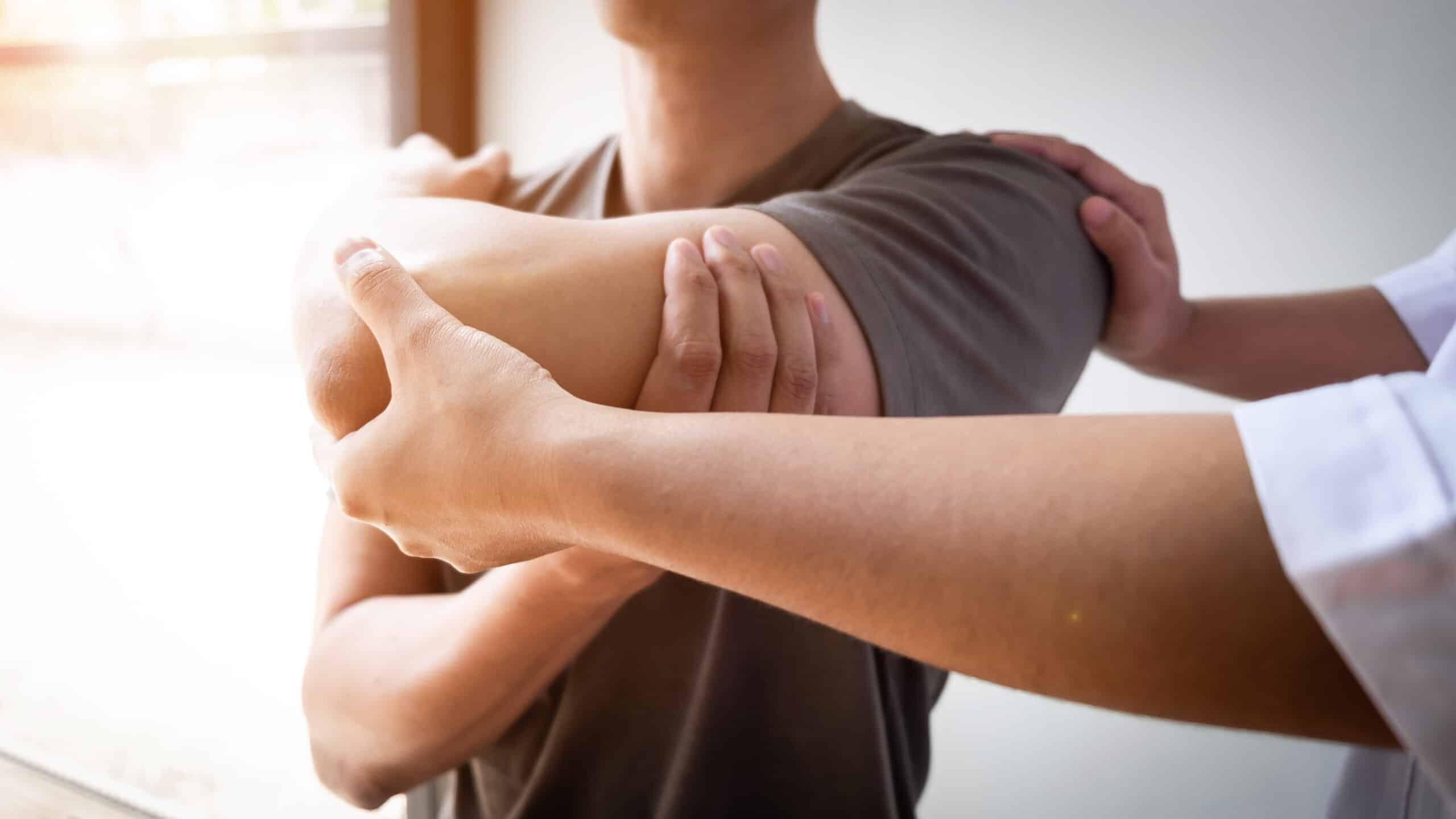 Therapist Treating A Male Injured By Rotator Cuff Stretching Met